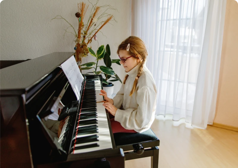 Child focused on piano music sheet
