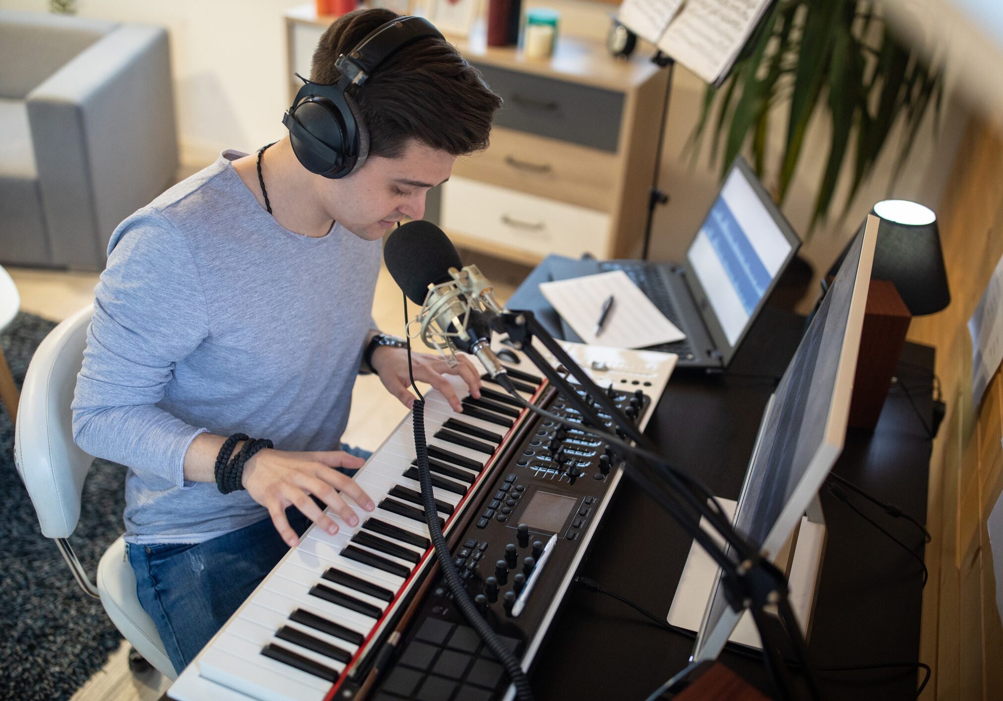 Talented young man recording new song in his home music studio